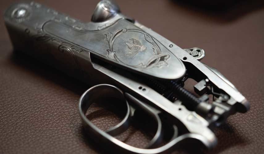 A raw shotgun action with two triggers on it,